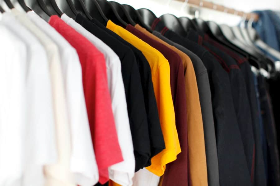 Blank t-shirts hanging on a rack ready for screen printing.